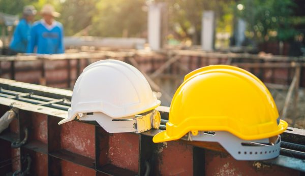 white and yellow helmet on steel in construction site